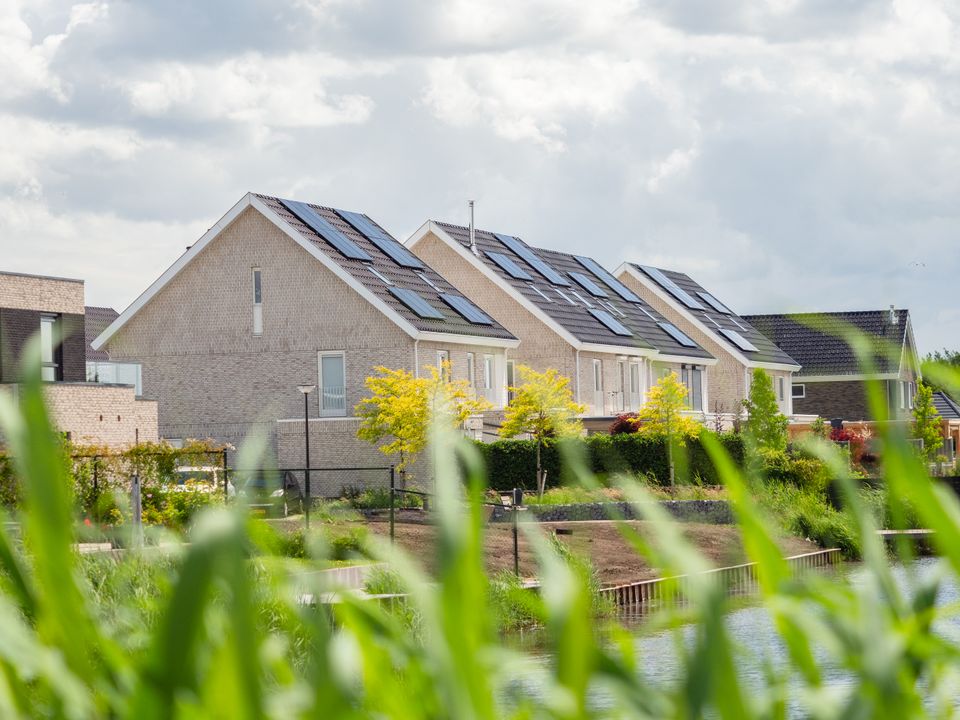 Een rijtje huizen met zonnepanelen