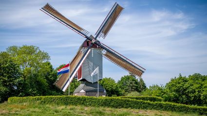 een molen in de zon met vlaggen