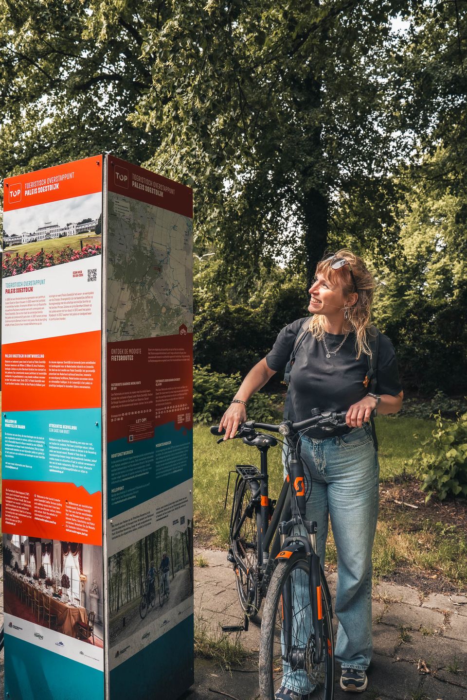 Vrouw bij een Toeristisch Overstap Punt informatiepunt in de buurt van het Baarnse Bos en Paleis Soestdijk op de Utrechtse Heuvelrug.
