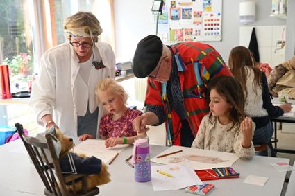 Kinderen maken met hulp van de kunstenaar een mooie tekening