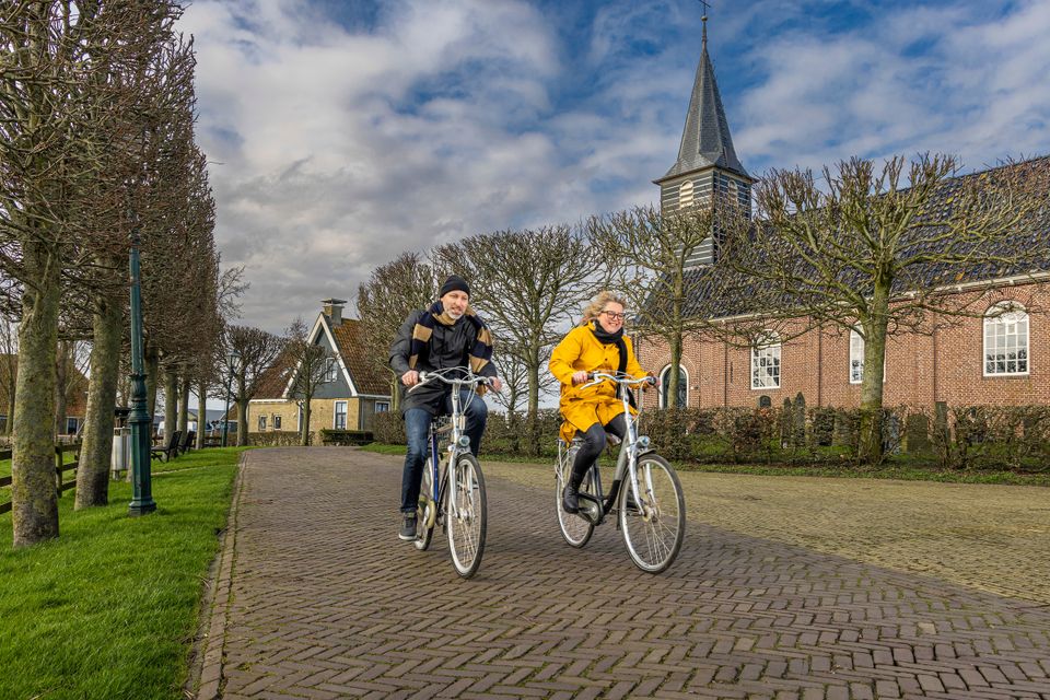 Een man en vrouw fietsen samen in de herfst door Sandfirden