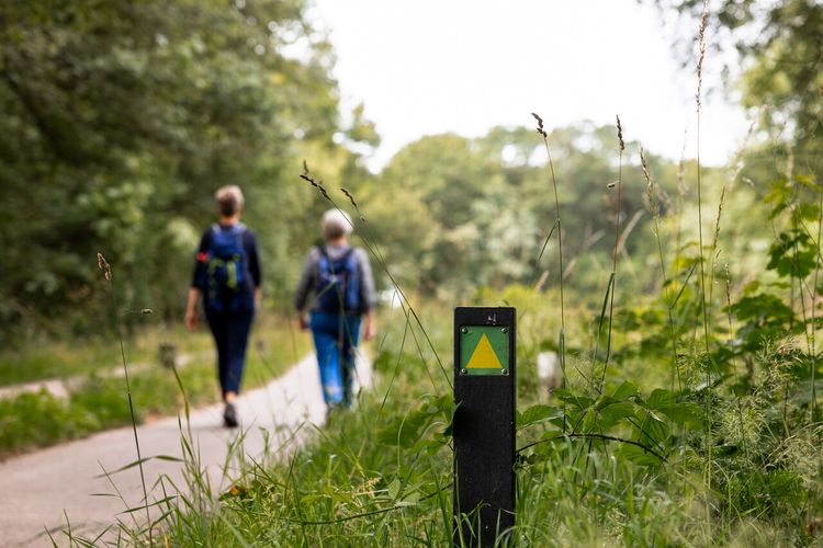 Wandelaars Goirle met paal op de voorgrond
