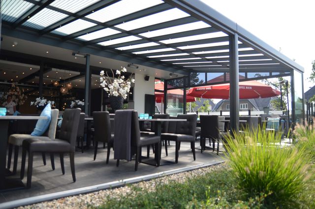 Overdekt en modern ingericht terras van Brasserie 1885 in Woudenberg, met comfortabele zitplaatsen en veel daglicht. De foto laat een sfeervolle plek zien voor eten en drinken in het centrum van Woudenberg.