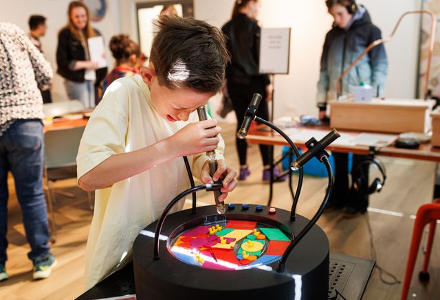 kind kijkt door een buis naar een tentoonstelling