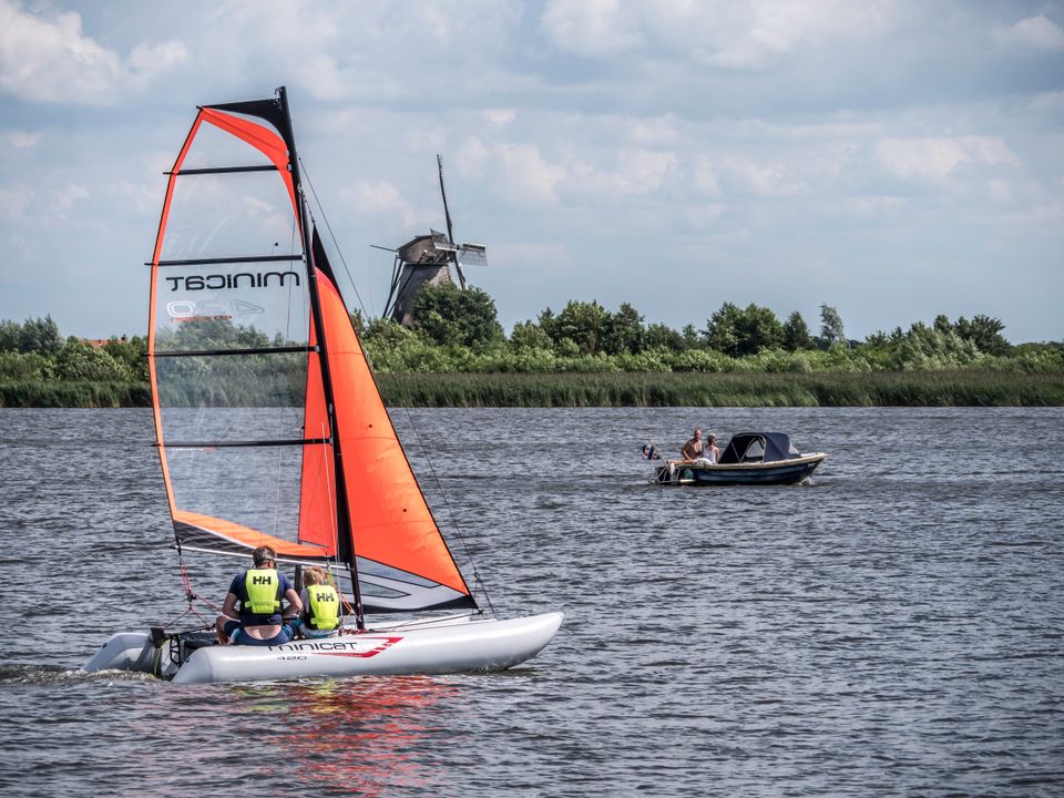 een sloepje en een zeilboot die varen op de Langwarder Wielen