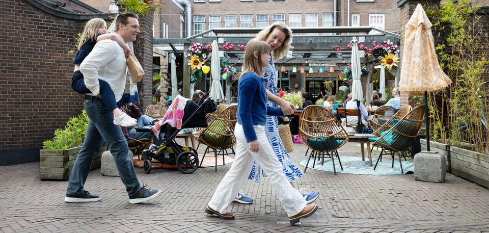 Gezin loopt in binnenstad voor een terras