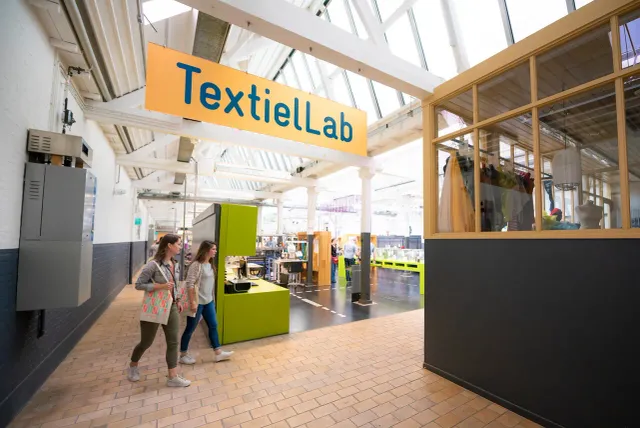 Twee dames lopen door het textiellab in het TexTielmuseum