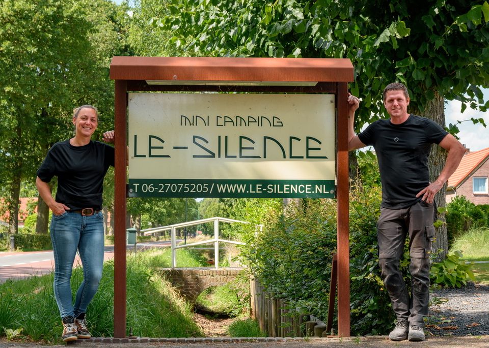 Eigenaren staan bij het bord bij de ingang van Camping le silence
