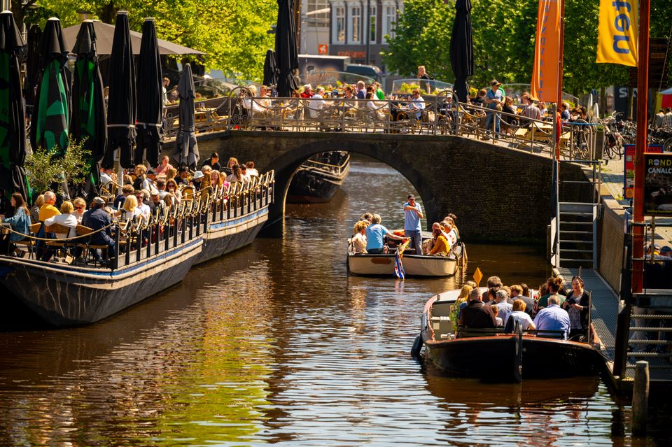 Zomerse dag in de binnenstad van de Leeuwarden met volle terrassen aan weerzijde van de grachten
