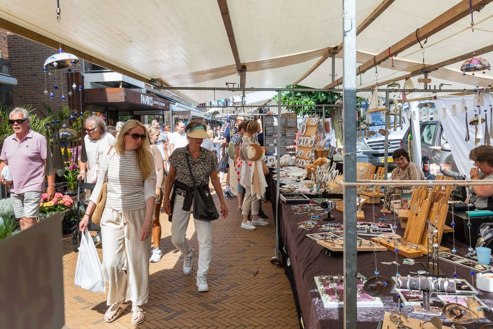 Marktkraam met creatieve spulletjes en klanten tijdens de jaarlijkse Toeristenmarkt in Katwijk aan Zee.