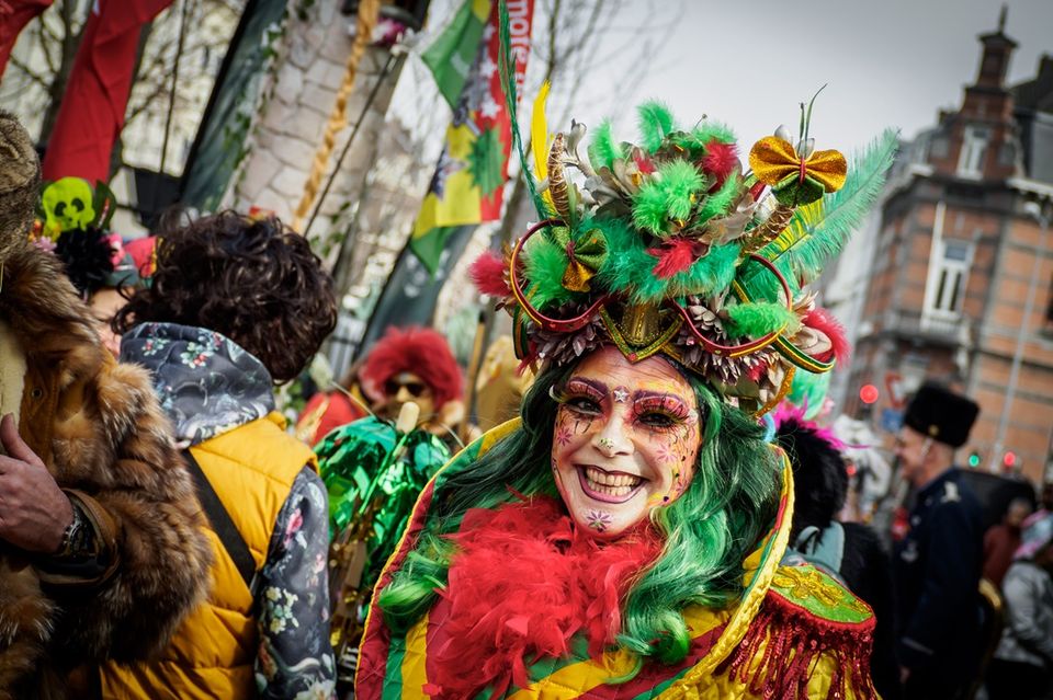 Vrouw in rood-geel-groen pak tijdens carnaval in Maastricht