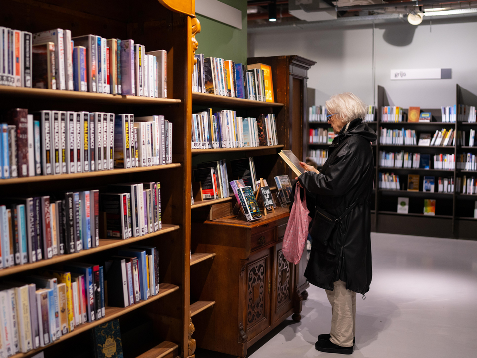 Een mevrouw in de bibliotheek van Delft zoekend naar een boek